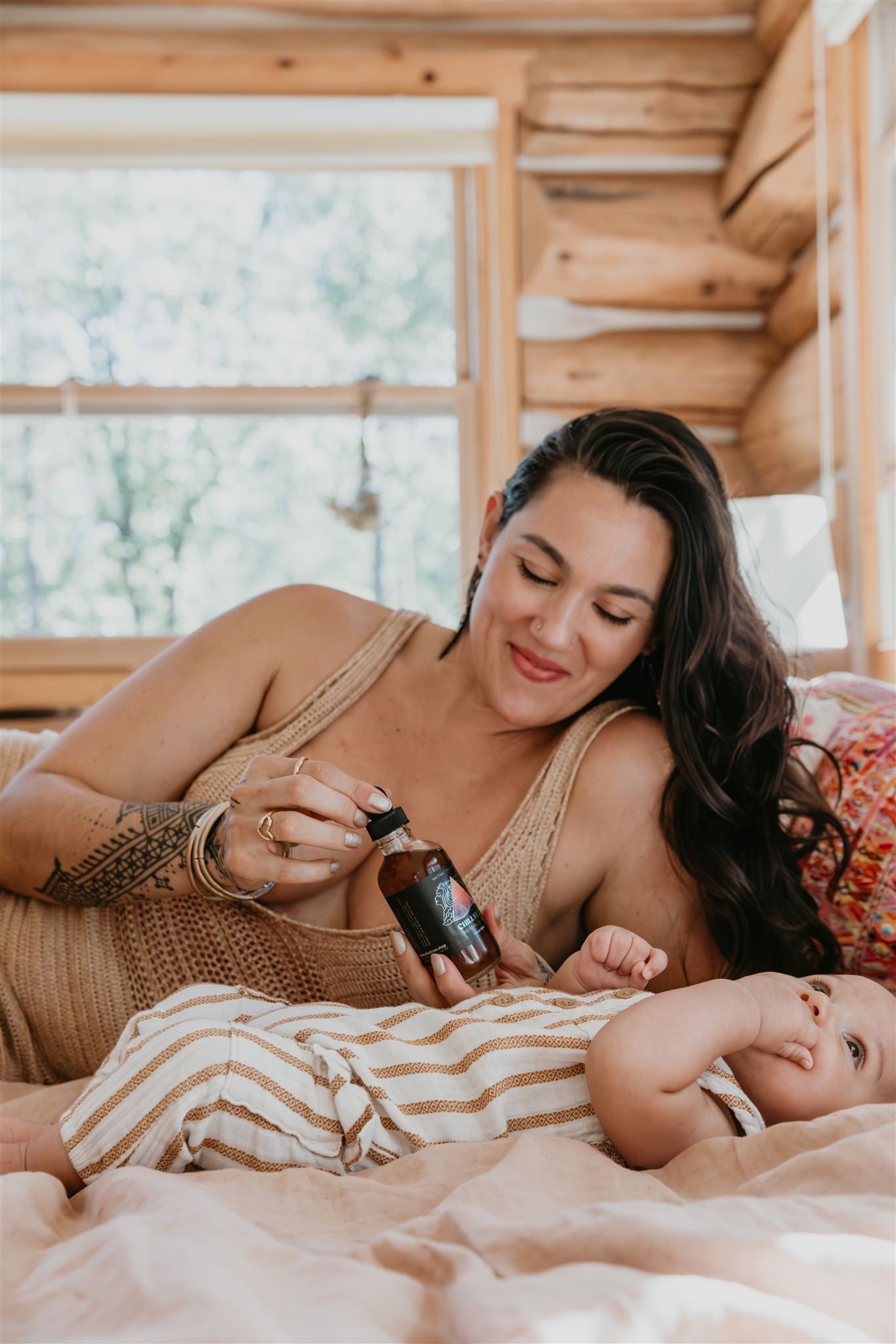 Woman holding a baby bottle with a baby in a cozy wooden cabin setting