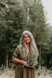 Woman holding plants and mythic medicine in a forest setting